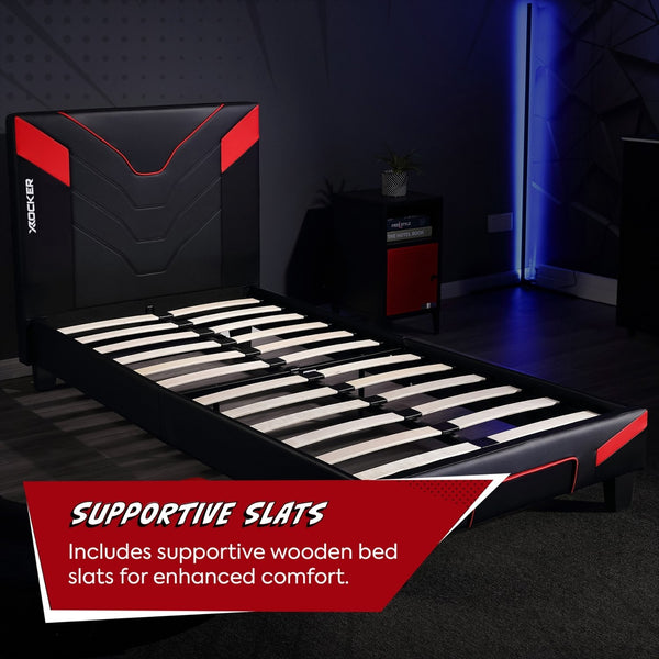 Black and red bed frame with supportive wooden slats in a dark room.