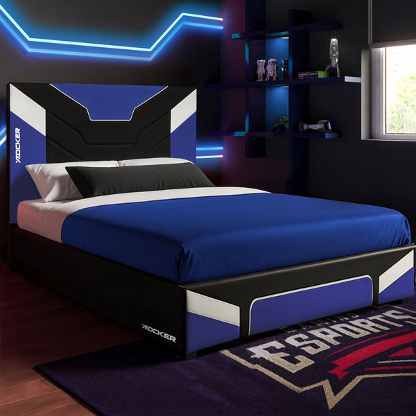 Bedroom with a bed featuring a blue and black color scheme, illuminated by neon lights.