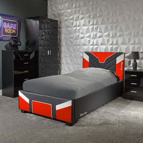 Modern bedroom with a bed featuring red, black, and white design, gaming setup, and geometric wall.