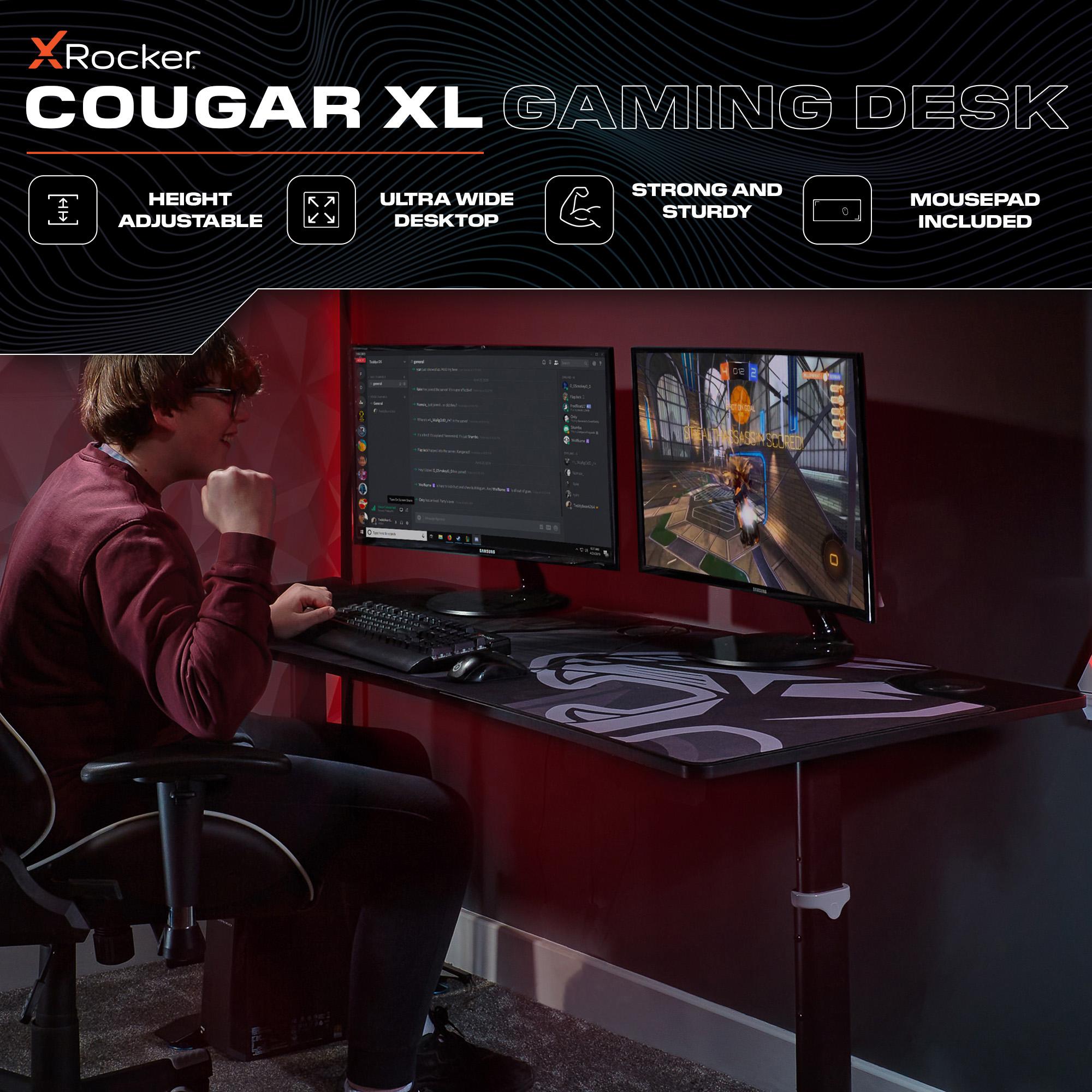 X rocker Cougar XL gaming desk with a person using it, featuring height adjustable, ultra wide desktop, and mousepad included.