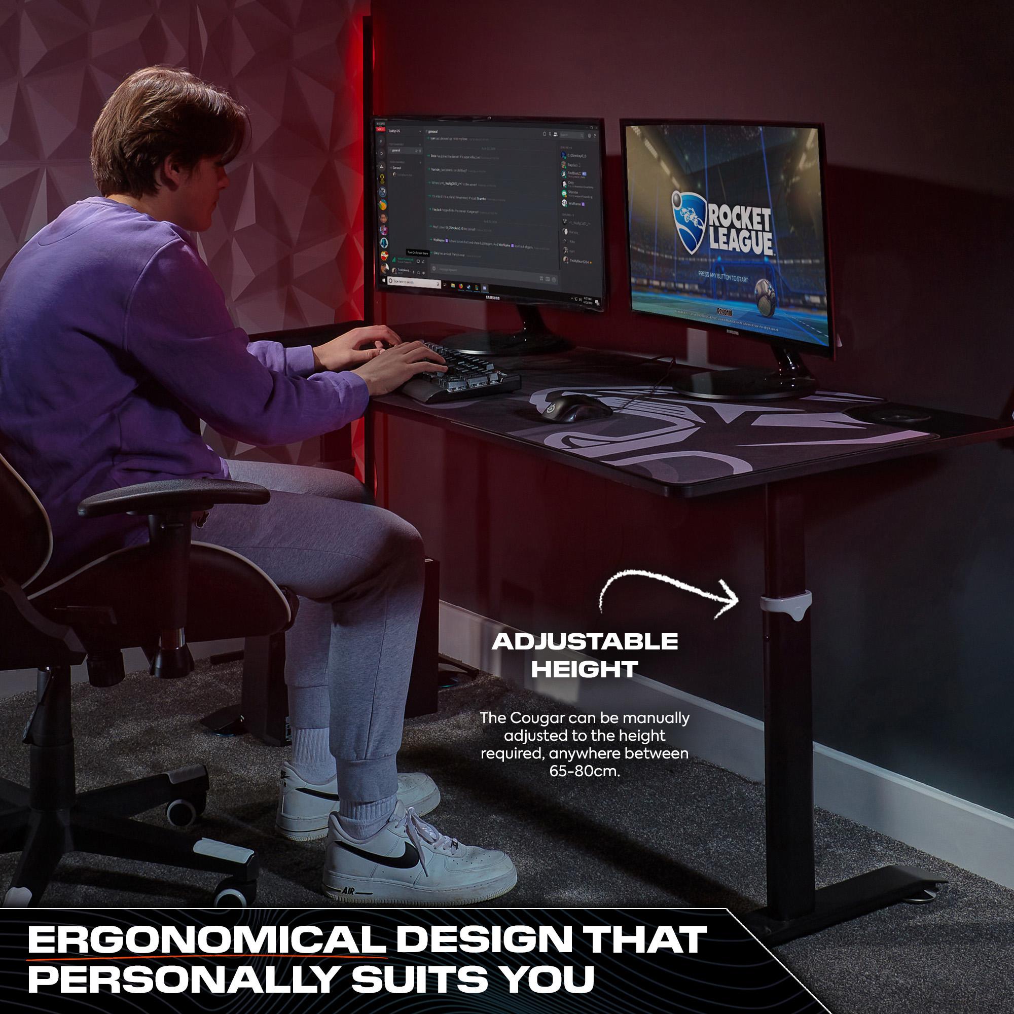 Person using a computer setup with an adjustable height desk in a room.