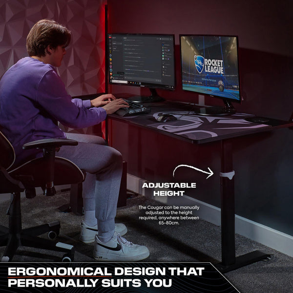 Person using a computer setup with an adjustable height desk in a room.