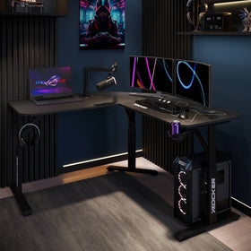 Gaming setup with a desk, laptop, monitors, and gaming equipment in a dark room.