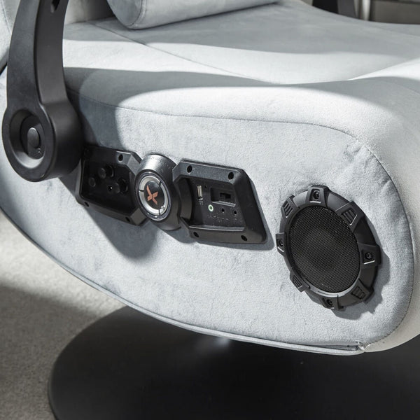 Close-up of a gaming chair with audio control panel and speakers.