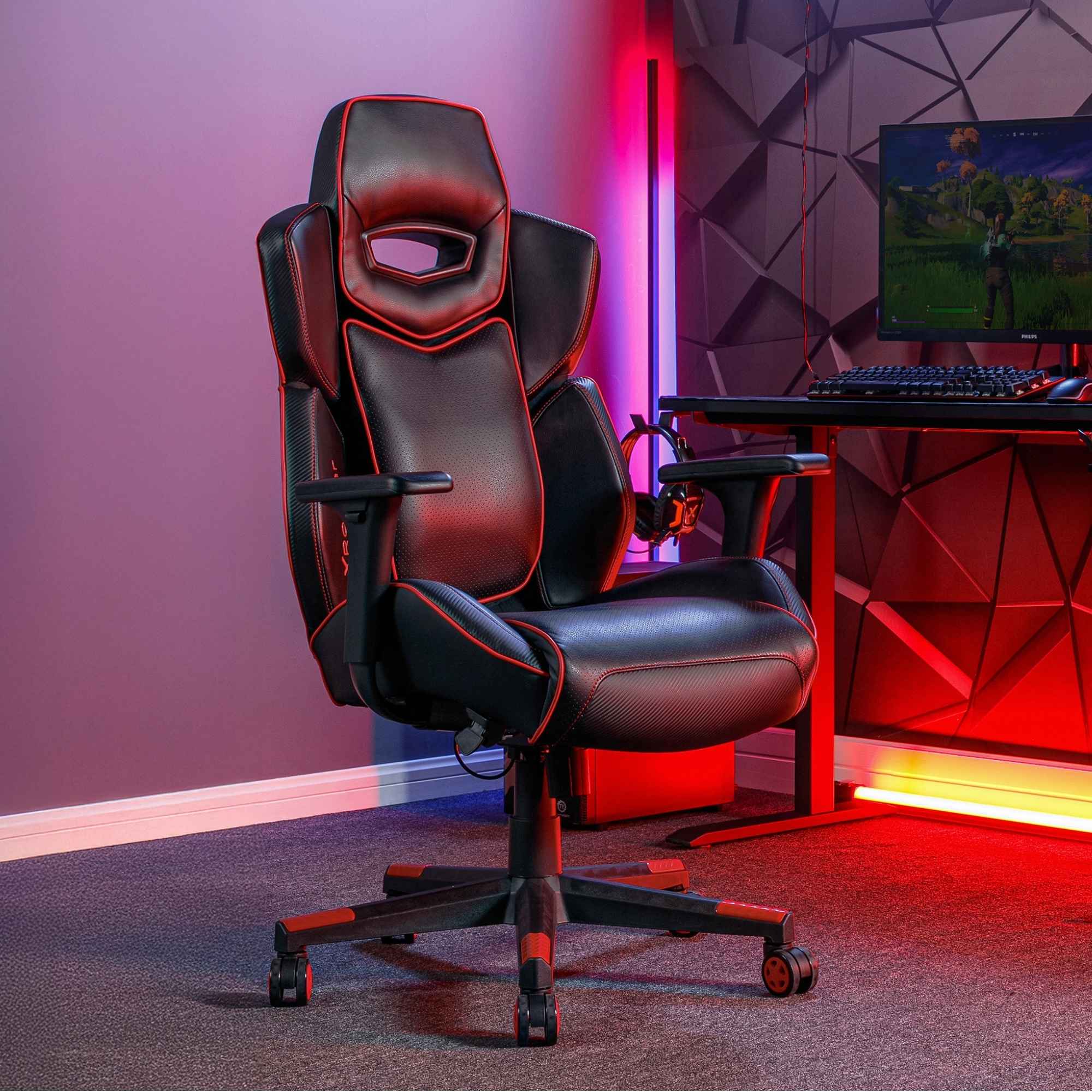 Gaming chair in a room with red lighting and a computer setup.