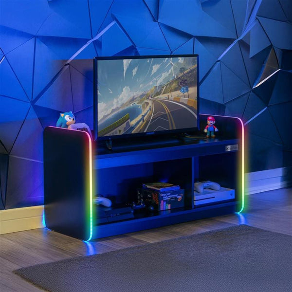 Gaming setup with a TV on a colorful stand against a geometric blue wall.