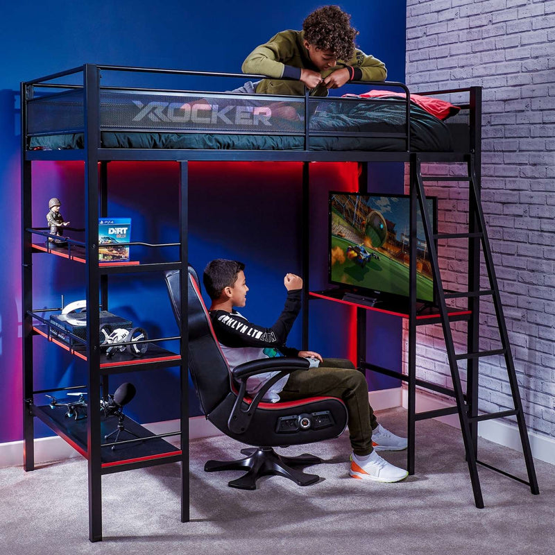 Gaming bedroom with a loft bed labeled 'X Rocker' and a person playing video games.