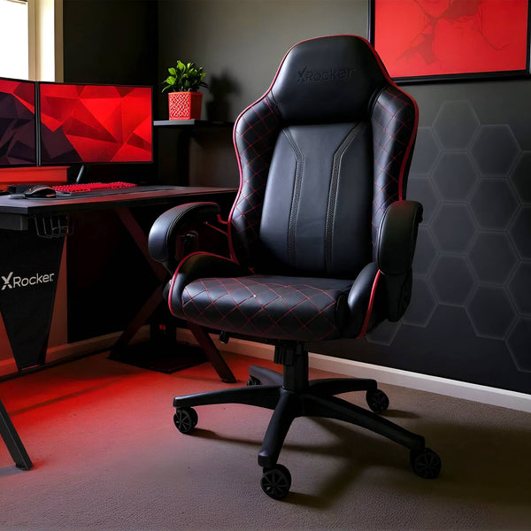 Gaming chair in a room with a computer setup and X rocker branding.