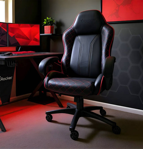 Gaming chair in a room with a computer setup and X rocker branding.