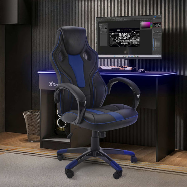 Gaming chair in front of a computer setup on a desk with X Rocker branding.