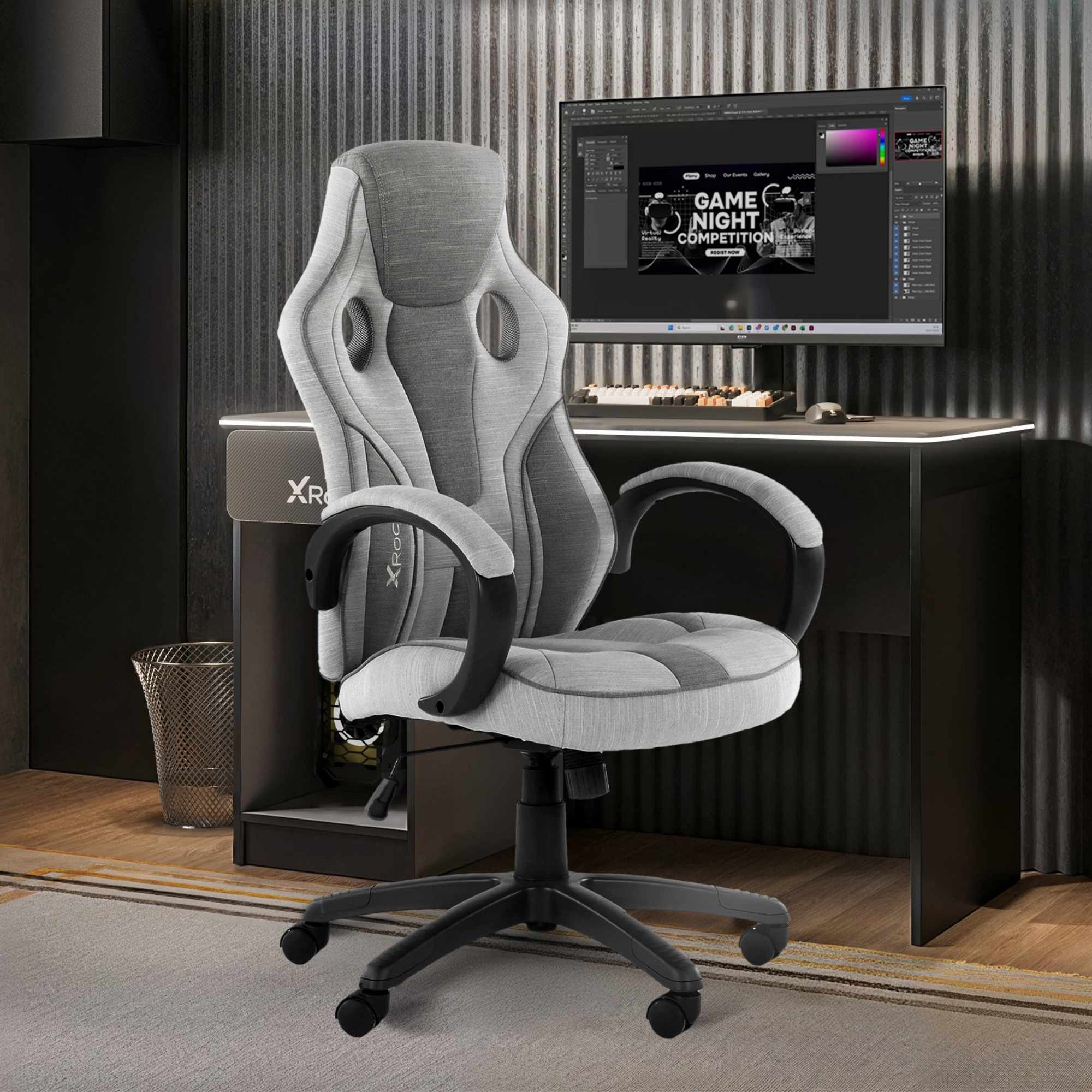 Gray gaming chair in front of a computer desk with a monitor displaying a game night graphic.