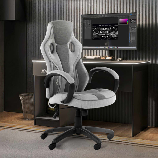 Gray gaming chair in front of a computer desk with a monitor displaying a game night graphic.