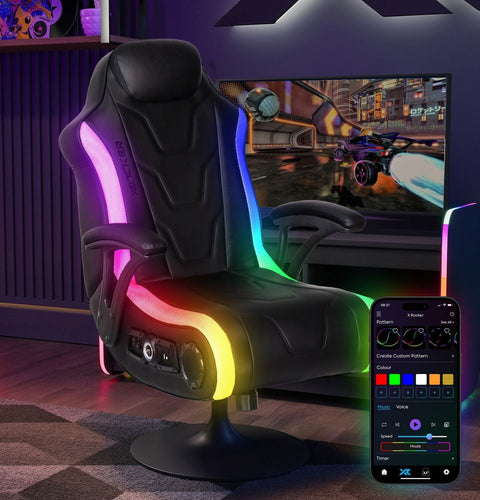 Gaming chair with RGB lighting and remote control in a room setup with a TV playing a racing game.
