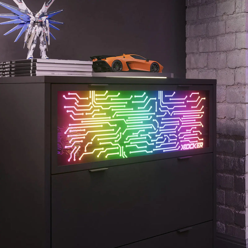 Neon light with circuit board design on a dark surface, with a toy car and model in the background.