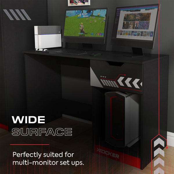 Gaming desk with multiple monitors and a computer tower, suitable for gaming setups.