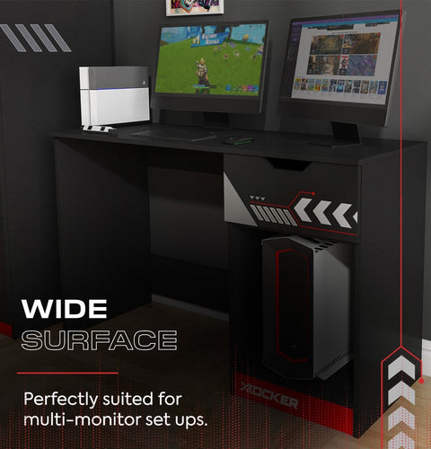 Gaming desk with multiple monitors and a computer tower, suitable for gaming setups.