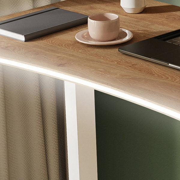 Wooden desk with a laptop, notebook, and cup on a blurred background
