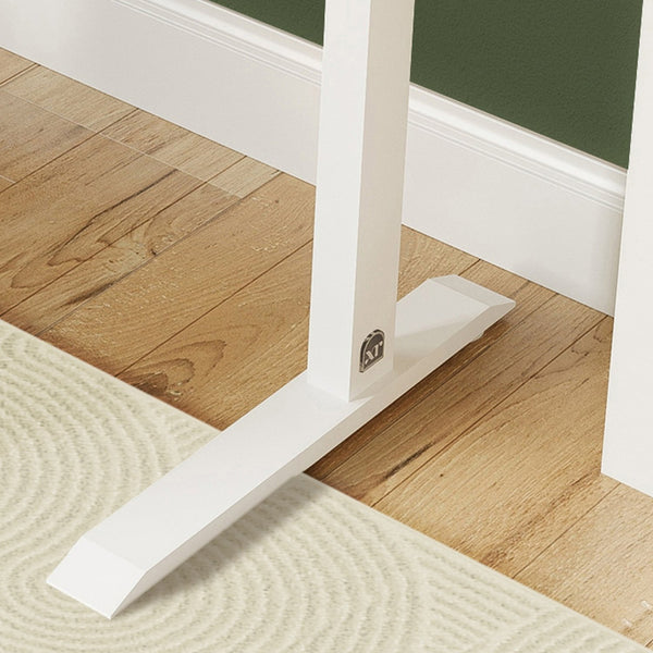 White baseboard trim on a wooden floor with a green wall in the background