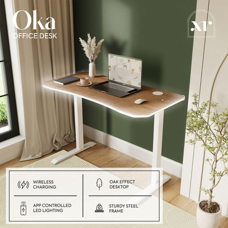 Wooden office desk with laptop, mouse, and decor items in a room with green walls and a window.