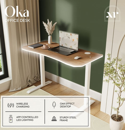 Wooden office desk with laptop, mouse, and decor items in a room with green walls and a window.