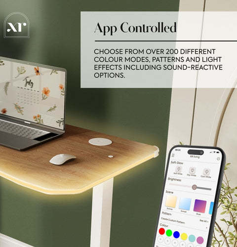 Laptop on a wooden desk with smartphone displaying app controls for color modes and light effects.