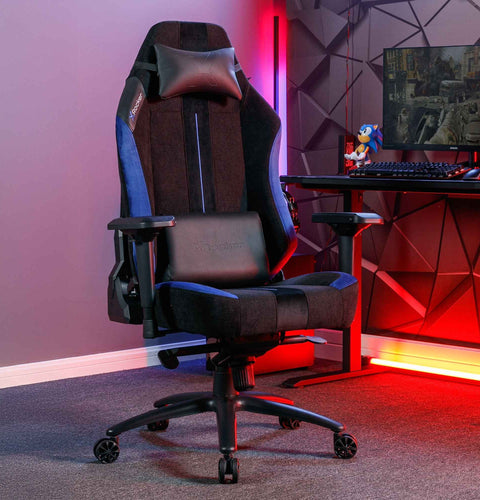 Gaming chair in a room with red lighting and a desk setup.