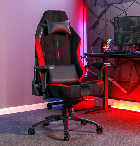 Gaming chair in a room with a desk and computer setup