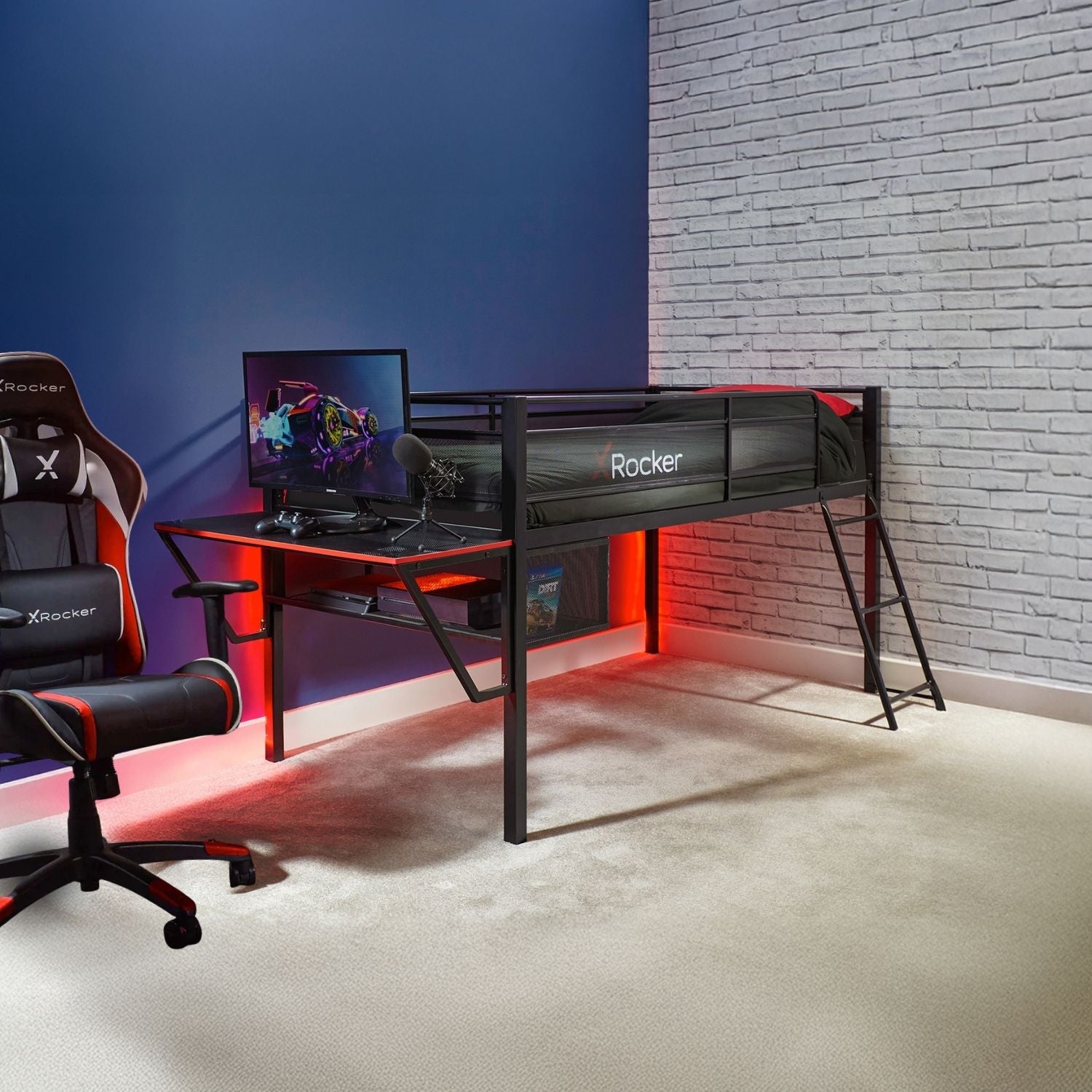 Mid sleeper gaming bed with a desk, chair, and computer monitor in a room with a blue wall and brick wall.