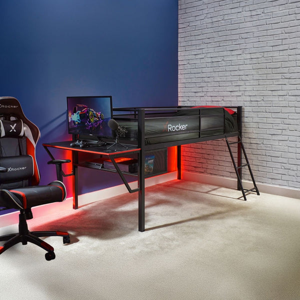 Mid sleeper gaming bed with a desk, chair, and computer monitor in a room with a blue wall and brick wall.