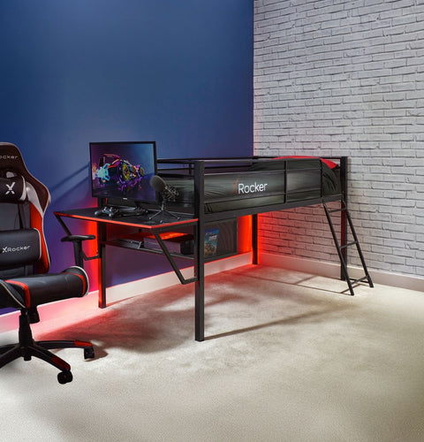 Mid sleeper gaming bed with a desk, chair, and computer monitor in a room with a blue wall and brick wall.
