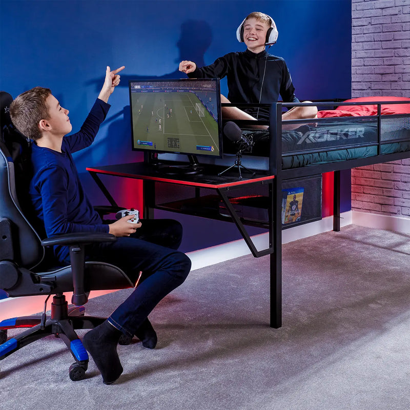 Two children playing video games in a bedroom with gaming setup.