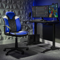 Gaming setup with a blue and black chair, desk, and dual monitors in a room with geometric wall design.