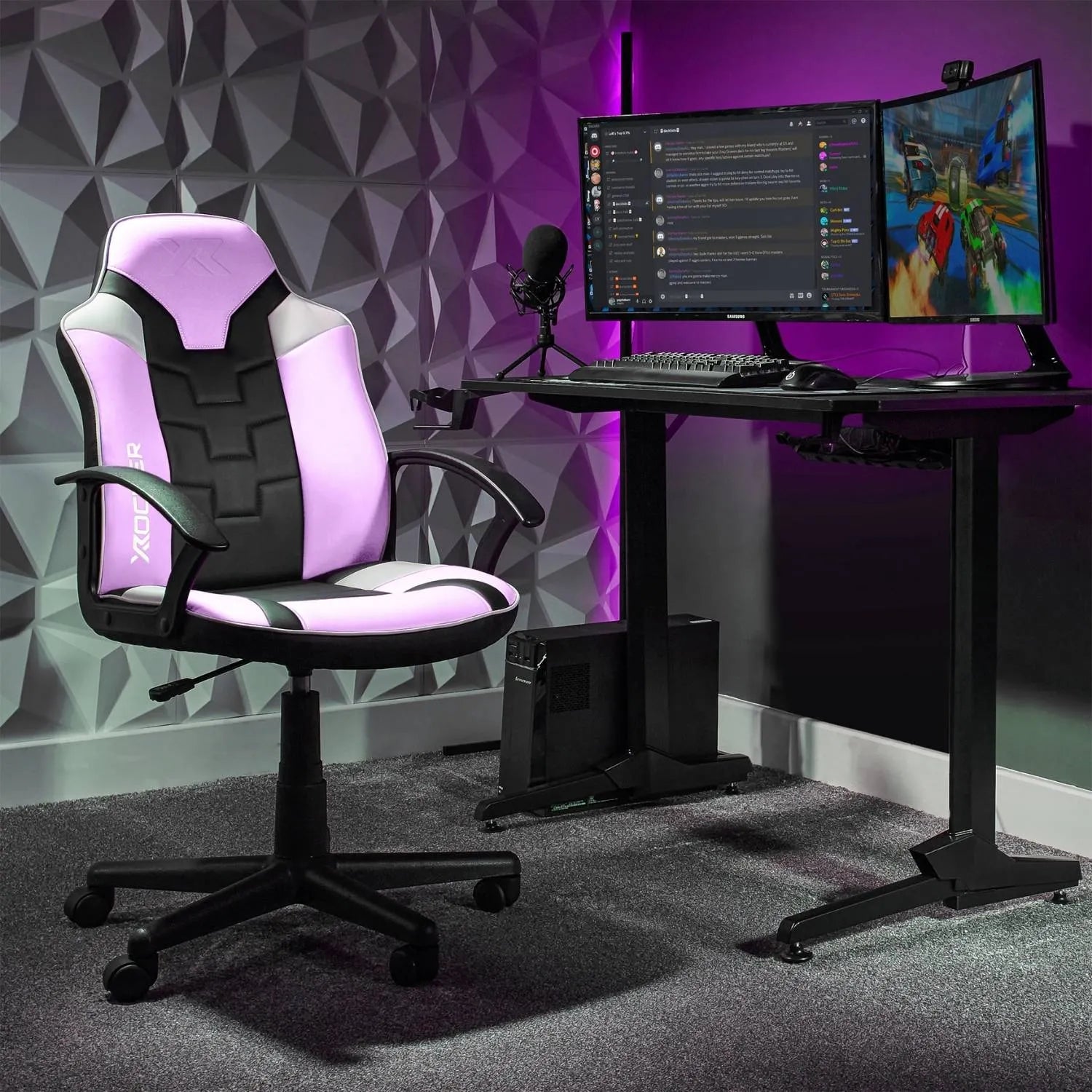 Gaming setup with a pink and black chair, desk, and dual monitors.