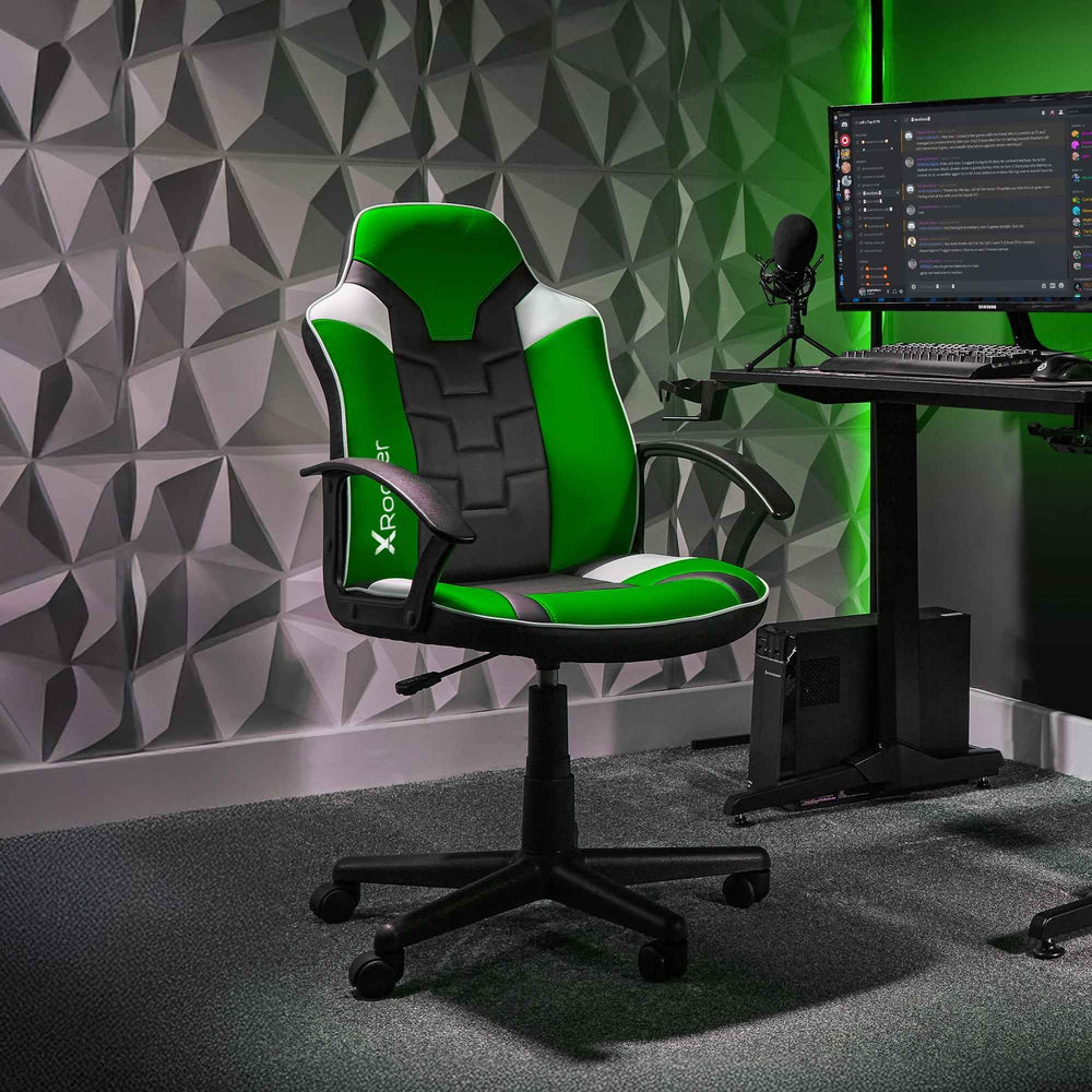 Gaming chair with green and black design in a room with geometric wall patterns and computer setup.