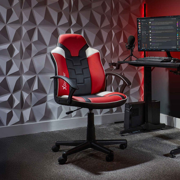 Gaming chair in a room with a geometric wall design and computer setup.