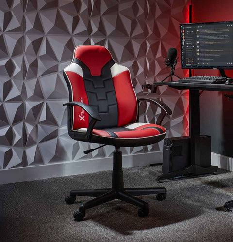 Gaming chair in a room with a geometric wall design and computer setup.