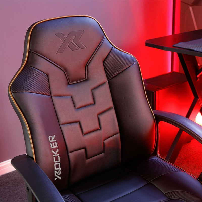 Black gaming chair with X rocker logo in a room with red lighting.