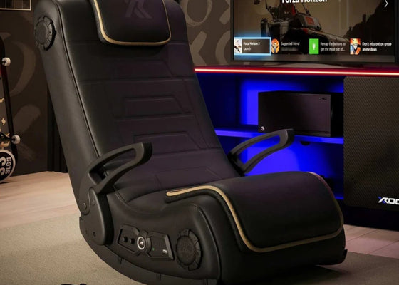 Black gaming chair with control panel in a room with a TV displaying 'Forza Horizon'.
