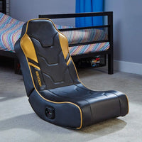 Black and gold gaming chair in a room with a bed and blue curtain.