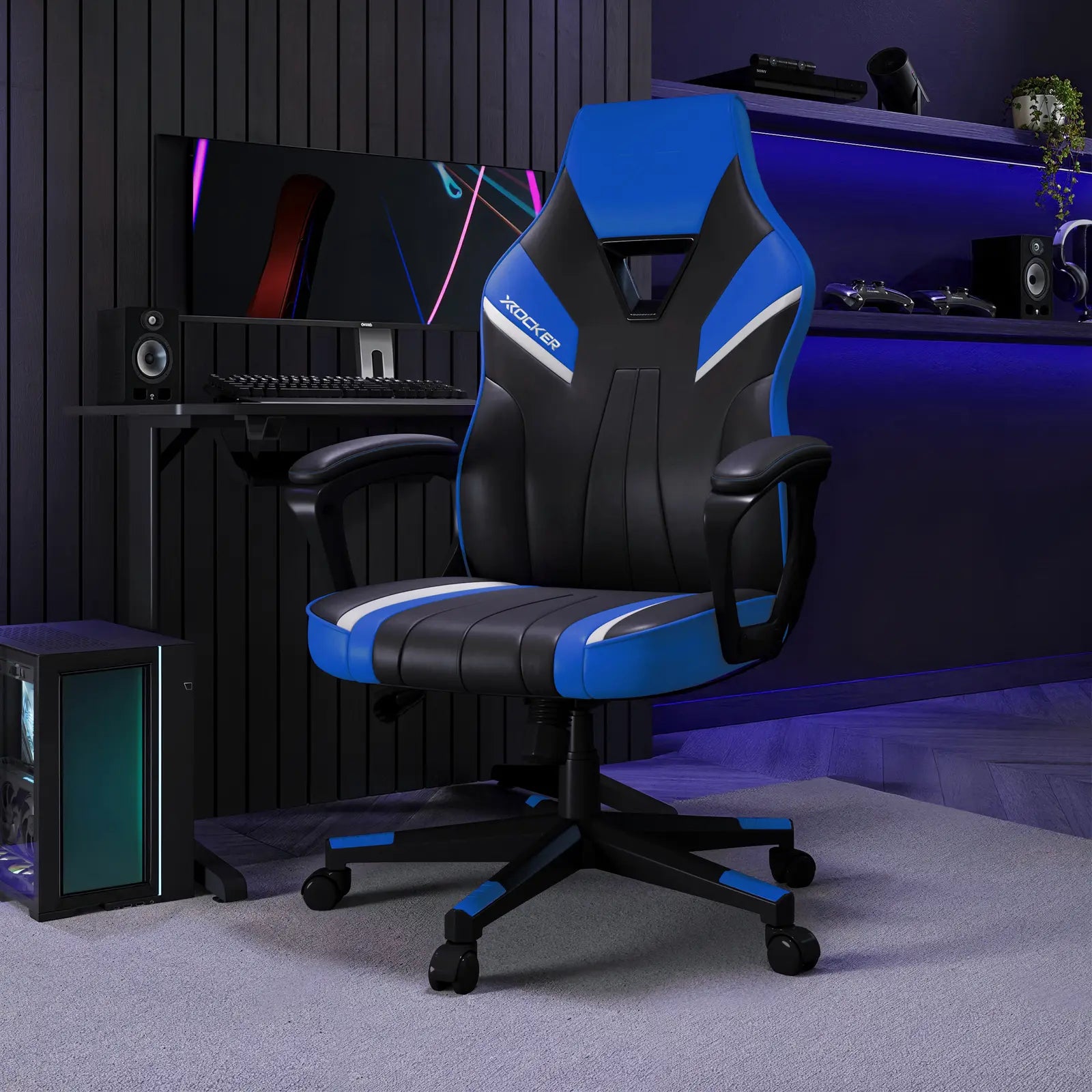Gaming chair with black and blue design in a room setup with computer equipment.