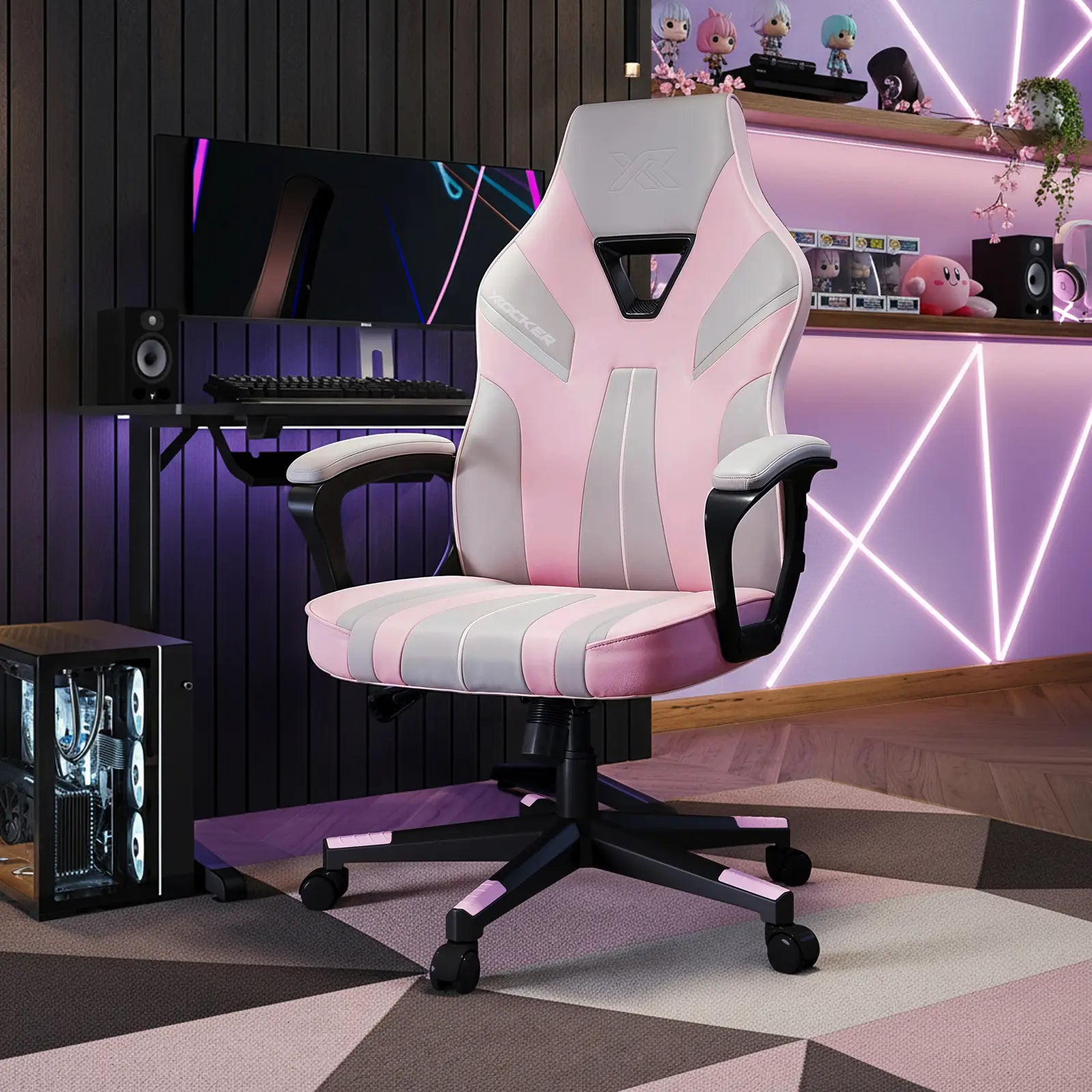 Gaming chair with pink and gray striped design in a room with gaming setup.