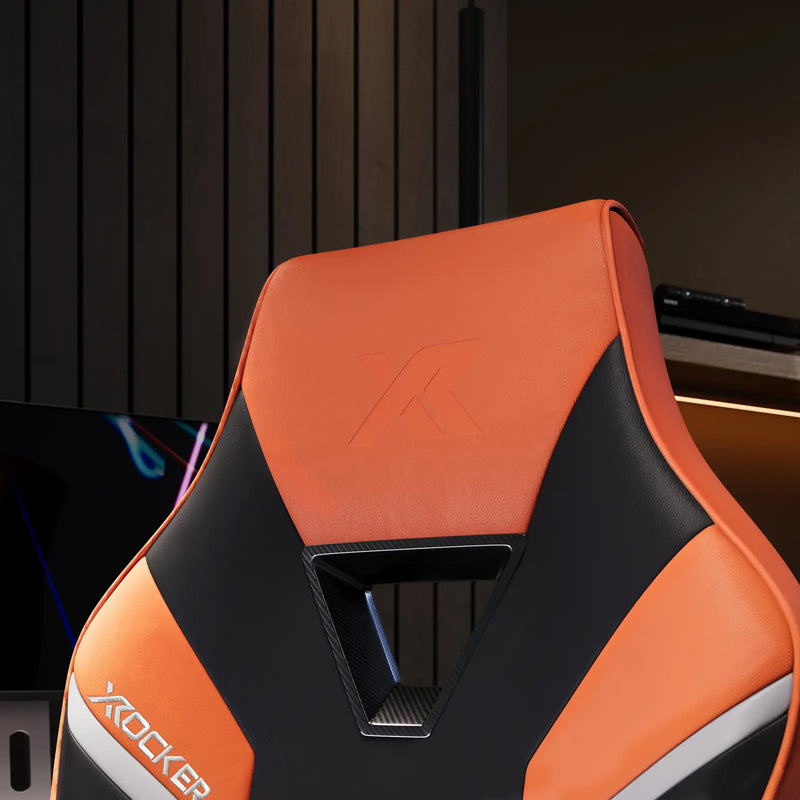 Orange and black gaming chair with 'X-Rocker' branding in a dark room setting.