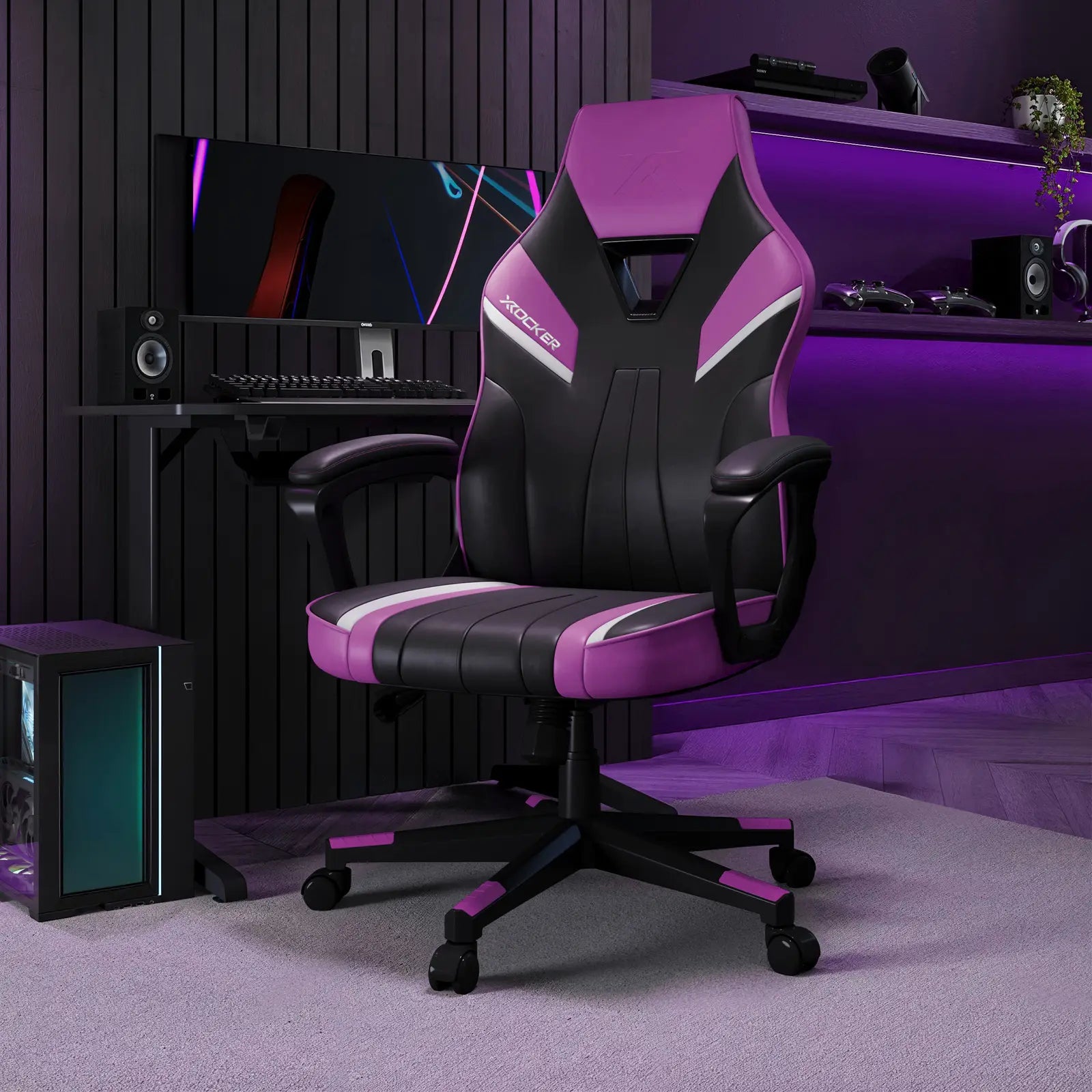 Gaming chair with purple accents in a dark room with computer equipment.