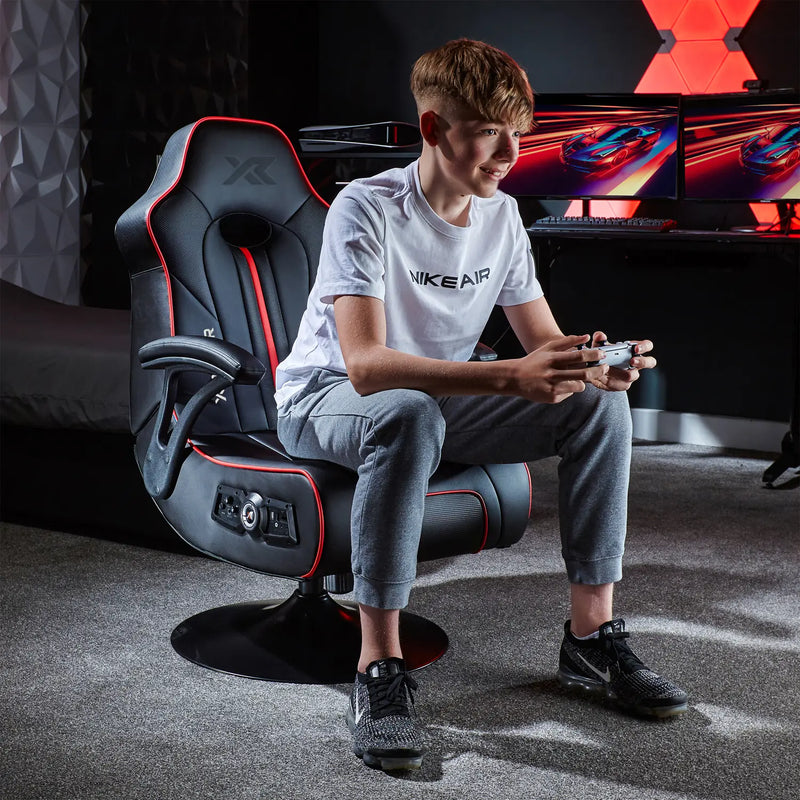 Person sitting in a Torque console gaming chair in a room with gaming setup