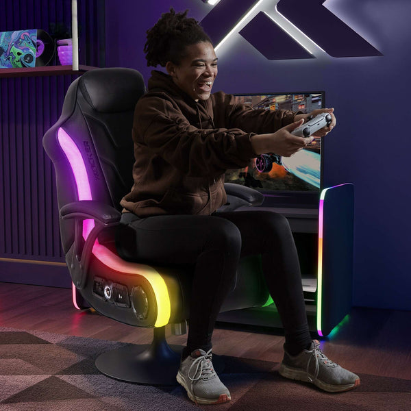 Person playing video games in a room with a gaming chair and colorful lighting.