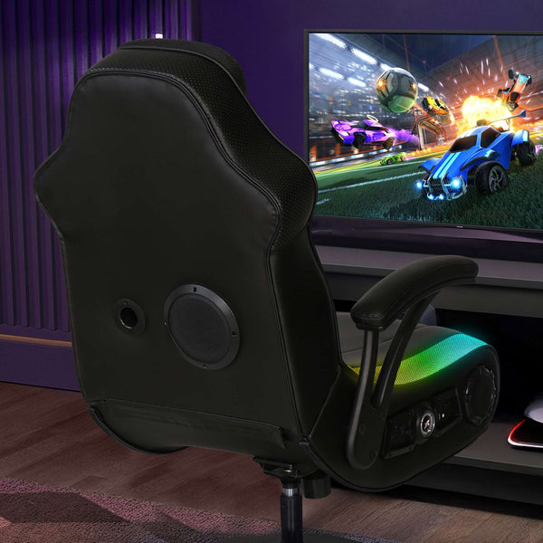 Black gaming chair in front of a TV displaying a racing game