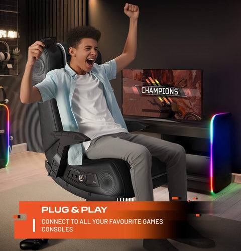 Person playing video games in a gaming chair with a TV screen displaying 'Champions'.