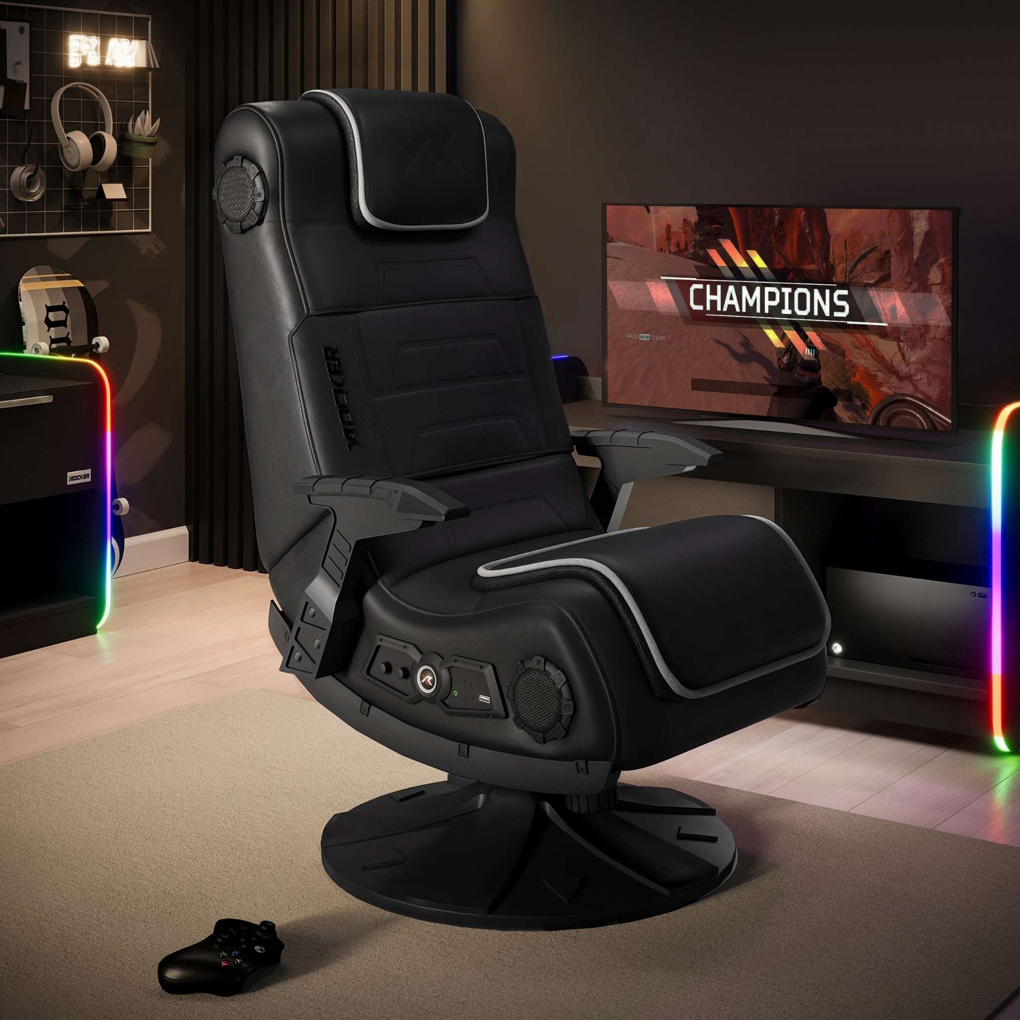 Gaming chair in a room with a monitor displaying 'Champions' and RGB lighting.