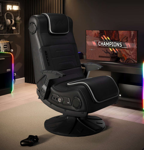 Gaming chair in a room with a monitor displaying 'Champions' and RGB lighting.
