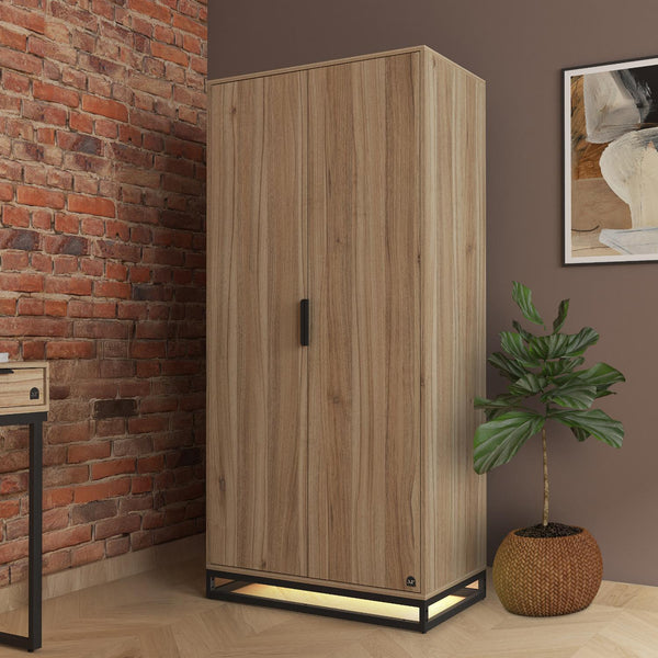 Wooden wardrobe against a brick wall with a plant and artwork in the background